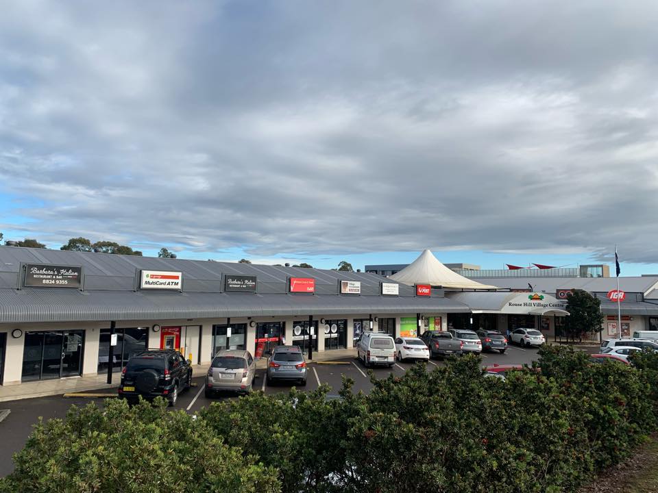 Rouse Hill Village Centre strip shops with parking, featuring local restaurants, Australia Post, IGA supermarket and a distinctive tent-roofed entry canopy